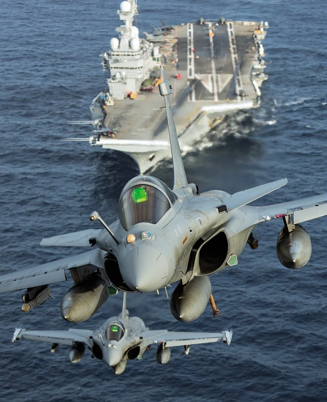 Avions de combats décollant d'un porte-avions en mer.