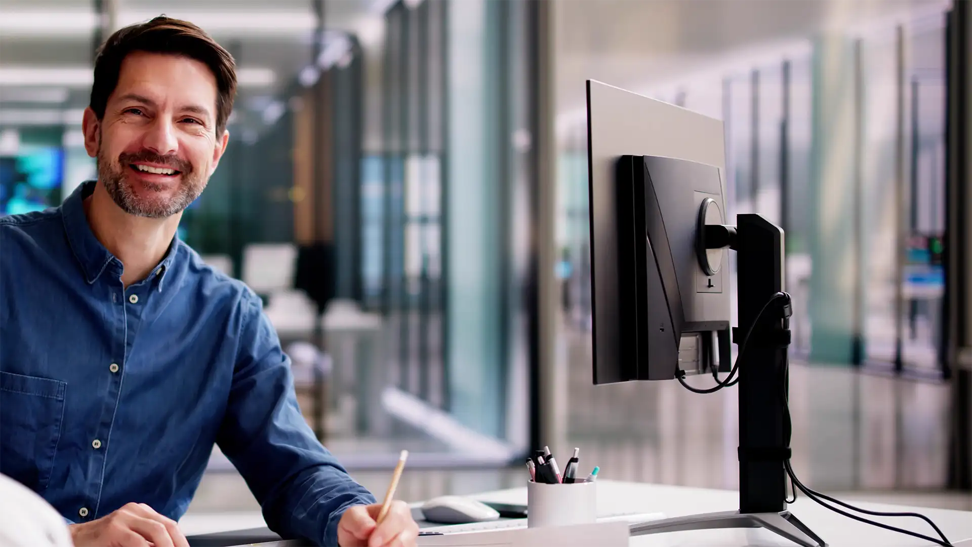 Ingénieur au travail devant un plan et un ordinateur.